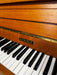 Kemble teak upright piano, keyboard and cabinet detail